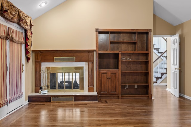 unfurnished living room featuring wood-type flooring and high vaulted ceiling