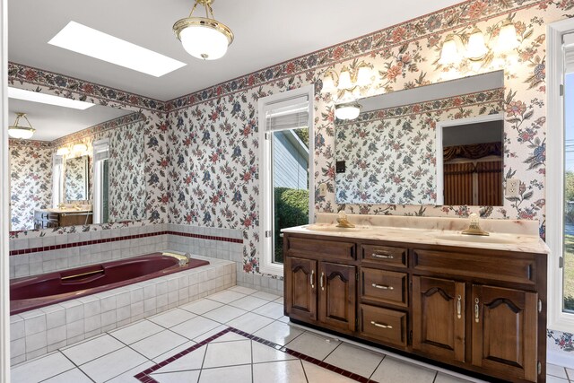 bathroom featuring vanity, a relaxing tiled tub, tile patterned floors, and a skylight