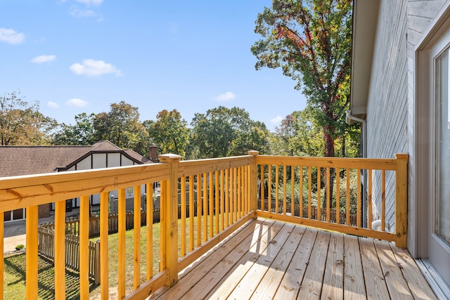 wooden deck featuring a lawn