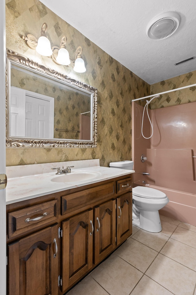 full bathroom featuring toilet, tile patterned flooring, shower / bathing tub combination, vanity, and a textured ceiling