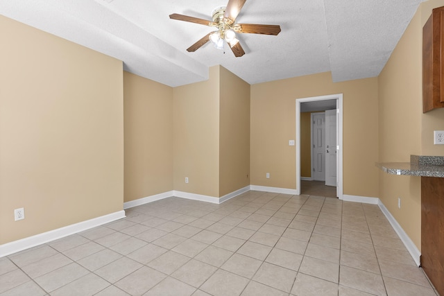 tiled empty room with a textured ceiling and ceiling fan