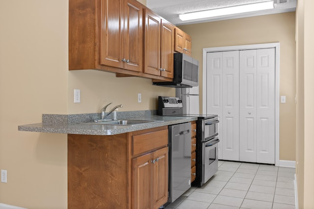 kitchen with sink, light tile patterned floors, and stainless steel appliances