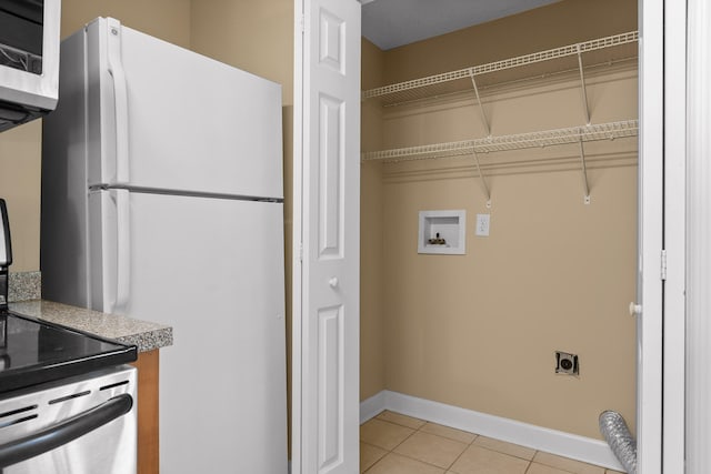 washroom with hookup for a washing machine, electric dryer hookup, and light tile patterned floors