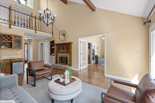 2508 Lake Dweller Ln, Hixson, TN 37343 - living area featuring high vaulted ceiling, wood finished floors, a chandelier, beamed ceiling, and a brick fireplace