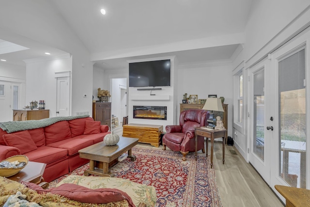 living room featuring lofted ceiling and light hardwood / wood-style flooring