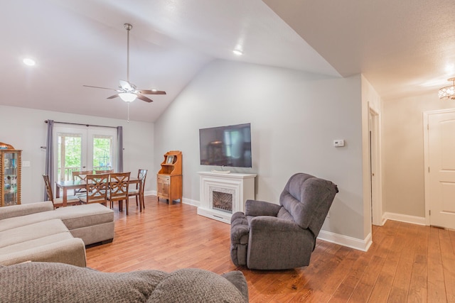 living room with ceiling fan, wood-type flooring, and vaulted ceiling