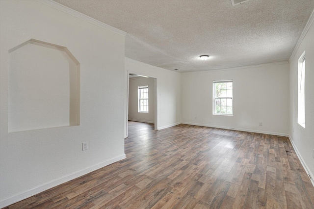 spare room with dark wood-type flooring, ornamental molding, and a textured ceiling