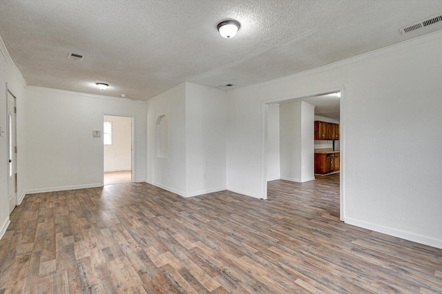 spare room with ornamental molding, a textured ceiling, and dark wood-type flooring