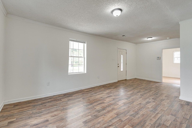 unfurnished room featuring ornamental molding, dark wood-type flooring, and a textured ceiling