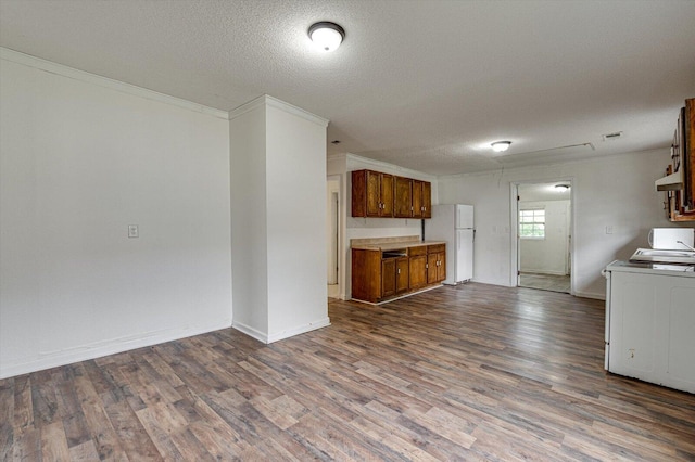 kitchen featuring washer / dryer, a textured ceiling, white fridge, and hardwood / wood-style flooring