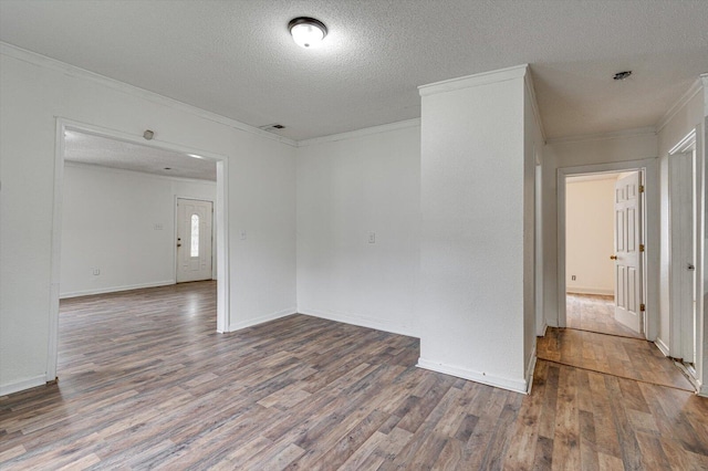 empty room with a textured ceiling, ornamental molding, and hardwood / wood-style floors