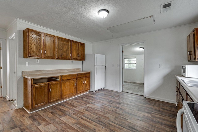 kitchen featuring dark wood-type flooring, sink, crown molding, a textured ceiling, and white appliances