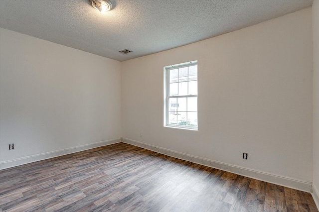 empty room with a textured ceiling and wood-type flooring