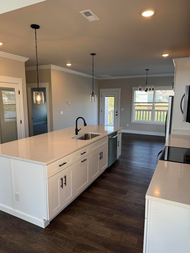 kitchen featuring appliances with stainless steel finishes, white cabinets, sink, and a center island with sink