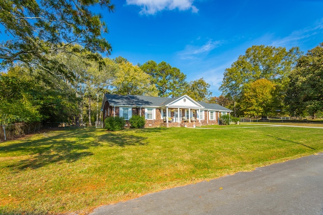 view of front of home with covered porch and a front lawn