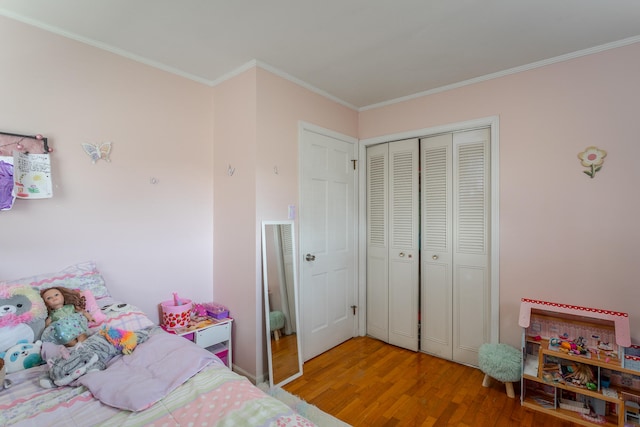 bedroom featuring ornamental molding, a closet, and hardwood / wood-style floors