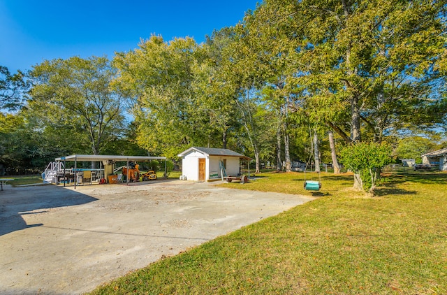view of yard featuring a carport and a storage unit