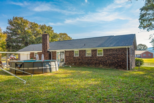 rear view of house featuring a yard
