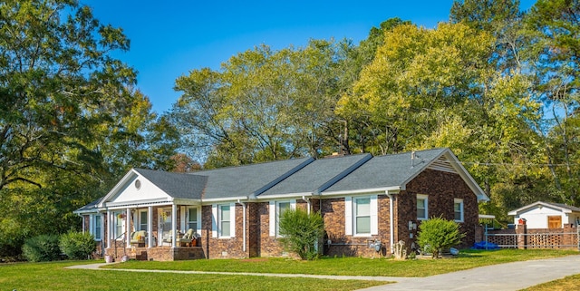 view of front of property featuring a porch, an outdoor structure, a front yard, and a garage