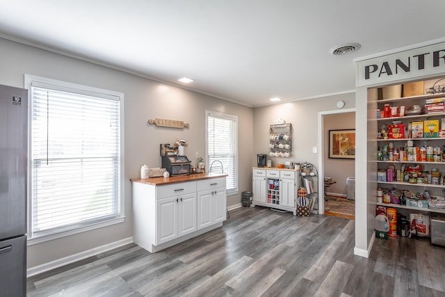 kitchen with butcher block counters, a wealth of natural light, and hardwood / wood-style floors