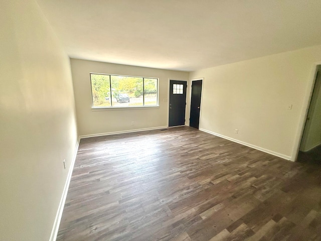 unfurnished room with dark wood-type flooring