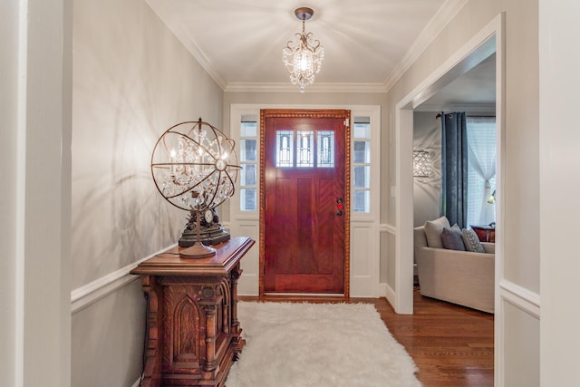 entryway with crown molding, a healthy amount of sunlight, a chandelier, and wood-type flooring