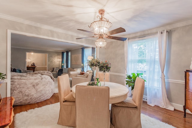 dining area with ornamental molding, hardwood / wood-style floors, and a chandelier