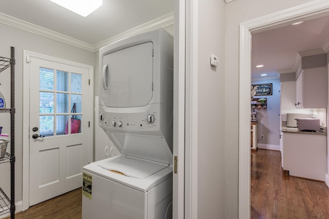 laundry area with crown molding, stacked washer and dryer, and dark hardwood / wood-style flooring