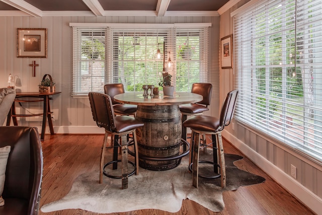 dining area featuring ornamental molding, beamed ceiling, and dark wood-type flooring