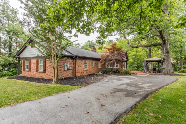 view of home's exterior with a gazebo and a lawn