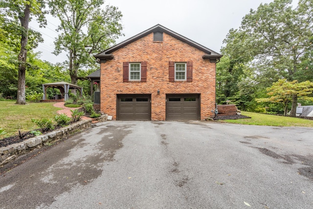 view of side of property featuring a garage and a lawn