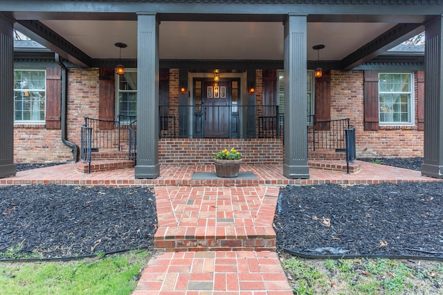 view of exterior entry featuring covered porch