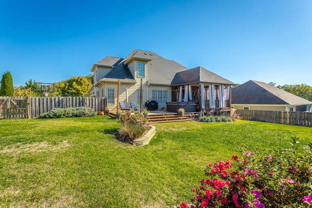 back of property featuring a wooden deck, a sunroom, and a yard