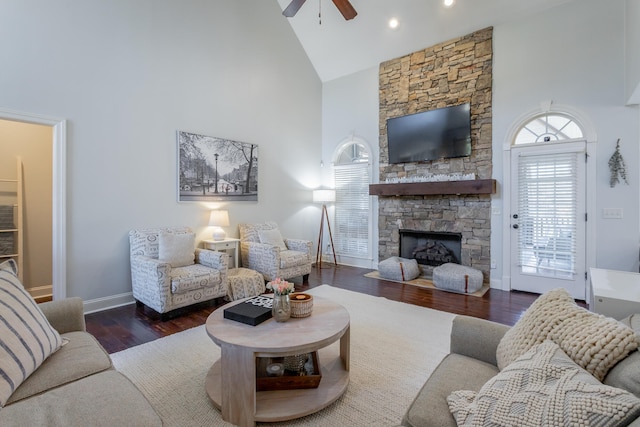 living room with high vaulted ceiling, dark wood-type flooring, ceiling fan, and a fireplace