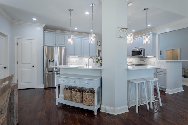 kitchen with stainless steel appliances, dark wood-type flooring, pendant lighting, and kitchen peninsula