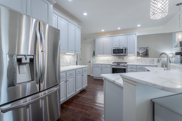 kitchen with stainless steel appliances, white cabinetry, sink, dark wood-type flooring, and pendant lighting