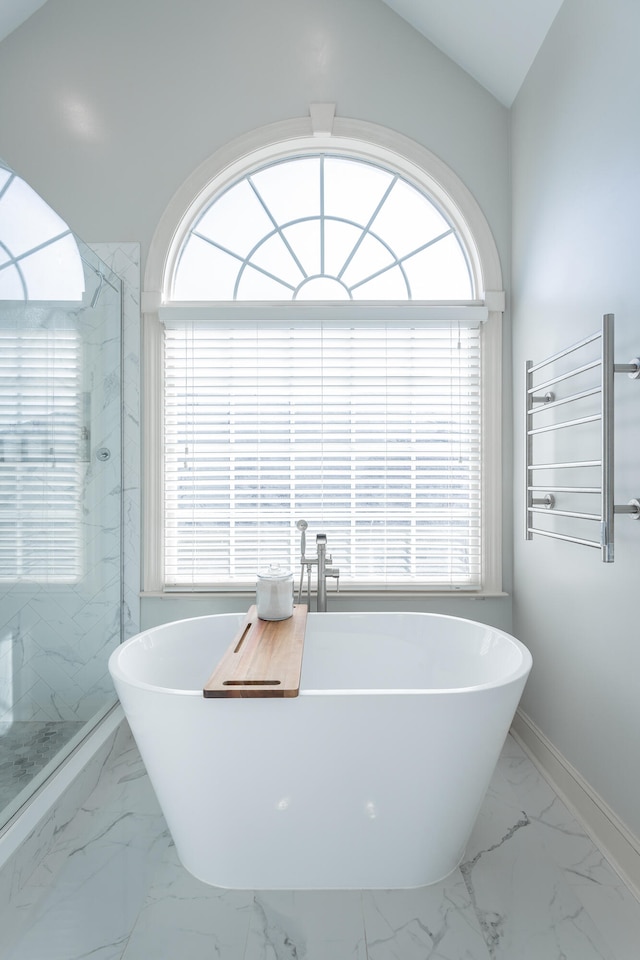 bathroom featuring shower with separate bathtub, radiator, a wealth of natural light, and vaulted ceiling