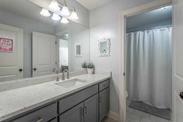 bathroom with tile patterned flooring, vanity, and toilet