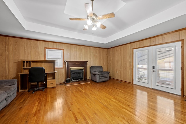 home office with light hardwood / wood-style floors, wood walls, and plenty of natural light