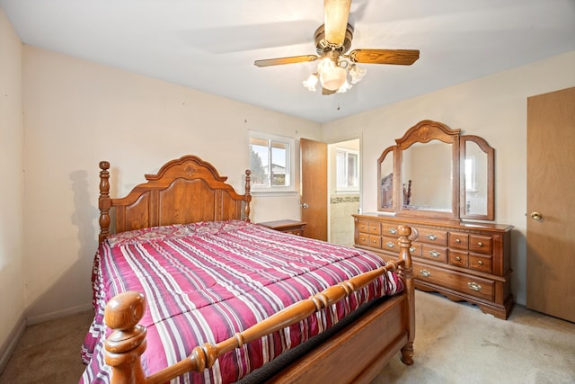 bedroom featuring connected bathroom, ceiling fan, and light colored carpet