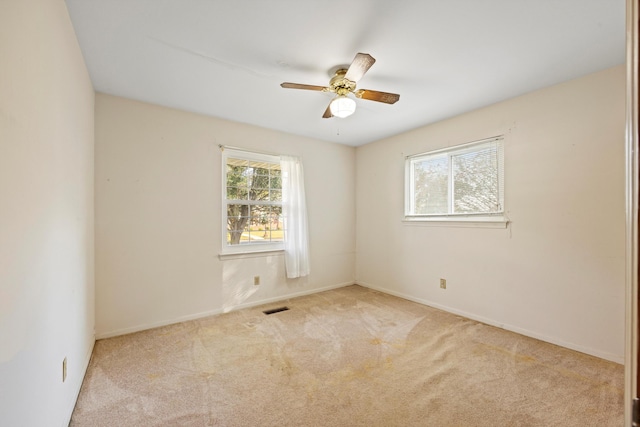 carpeted spare room featuring ceiling fan