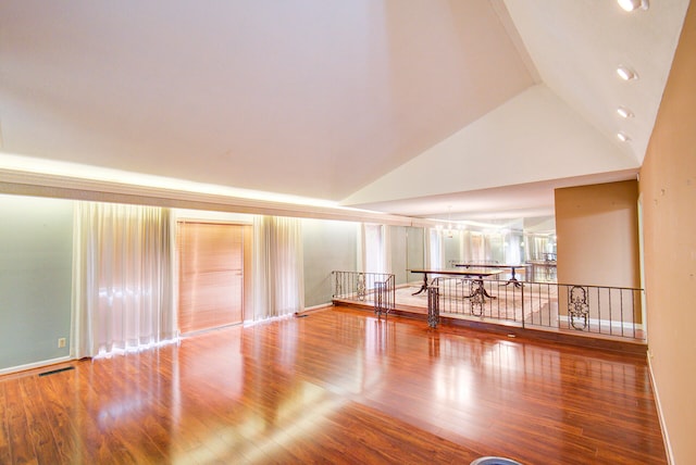 spare room featuring high vaulted ceiling and hardwood / wood-style floors