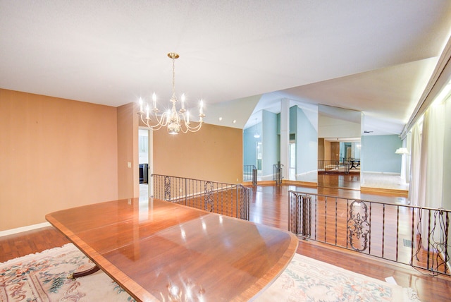 dining room with lofted ceiling, light hardwood / wood-style flooring, and a notable chandelier