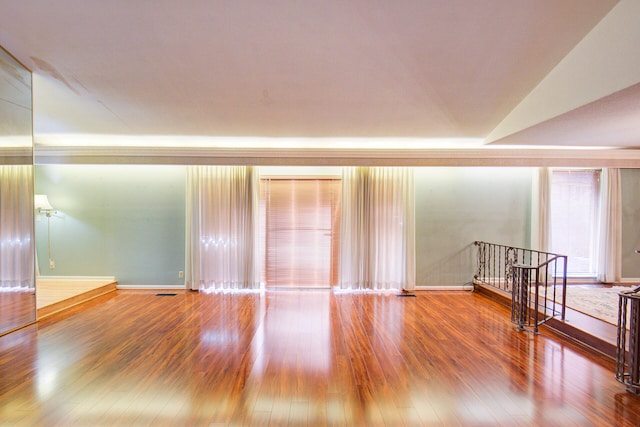 empty room featuring lofted ceiling and hardwood / wood-style floors