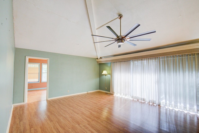 spare room featuring lofted ceiling with beams, wood-type flooring, and ceiling fan