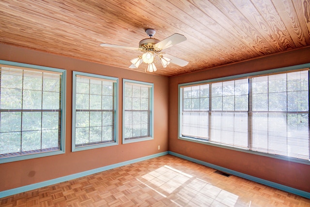 unfurnished sunroom featuring wood ceiling and ceiling fan