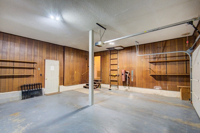 garage with a garage door opener and wood walls