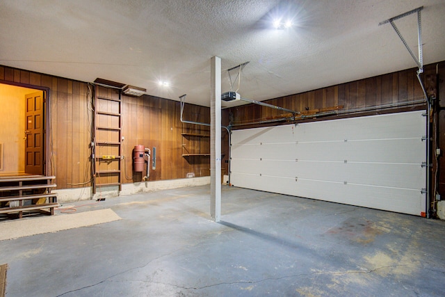 garage with a garage door opener and wooden walls