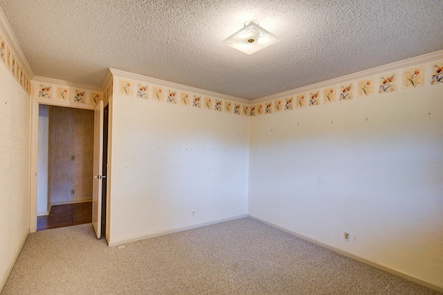 unfurnished room with ornamental molding, a textured ceiling, and light colored carpet