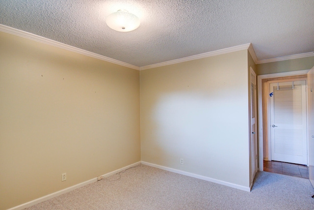 spare room with ornamental molding, a textured ceiling, and carpet flooring